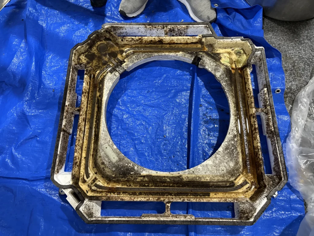 業務用天井カセットから取り外した部品に強い付着汚れが確認できる施工中の写真