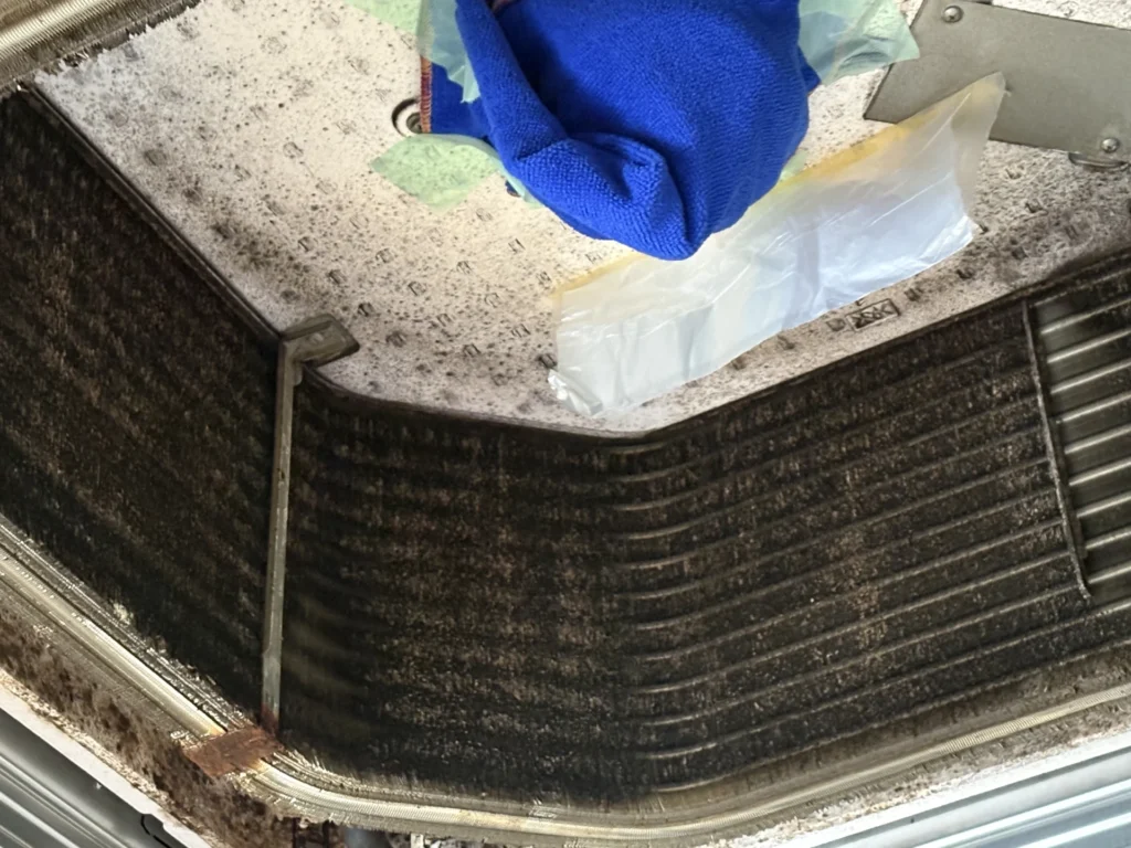 業務用天井カセット内部の熱交換器フィンに強い付着汚れが確認できる写真